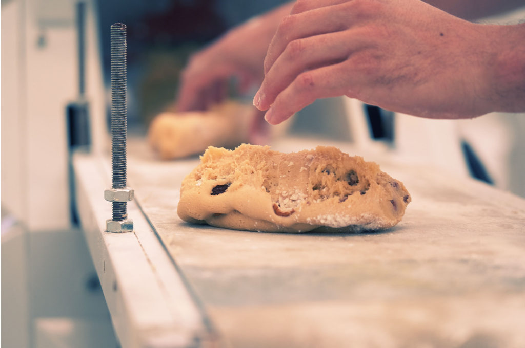 Hands dividing dough