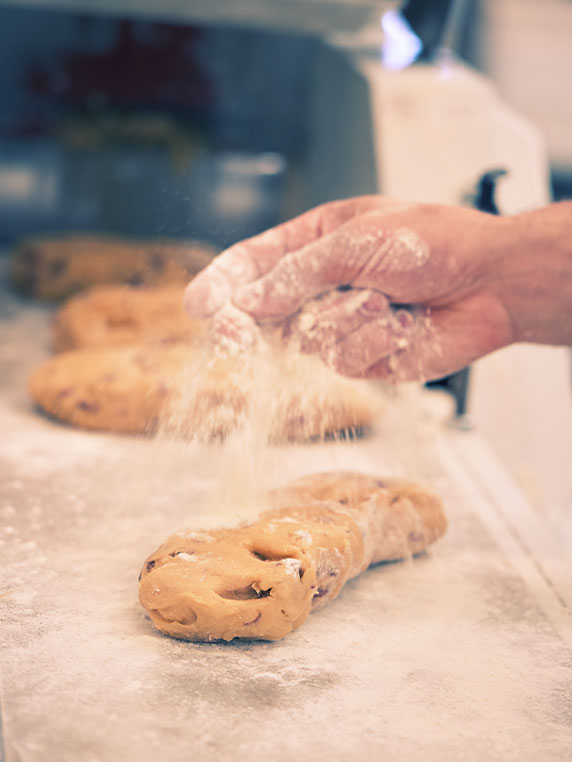 Hand spreading flour on dough